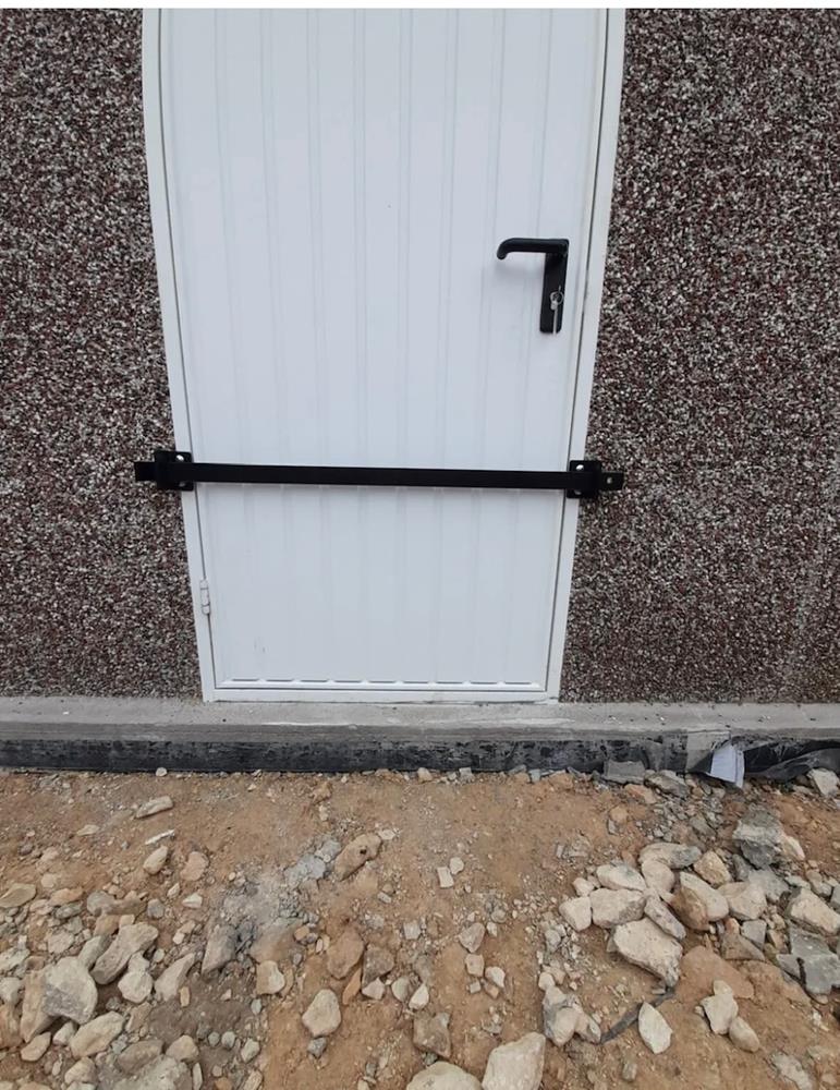 White door with security bar fitted across it.