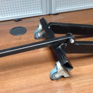 A dolly which fits to a scooter frame via the standard engine mount and the shock mount and allows you to move/store your engineless scooter with ease.  title