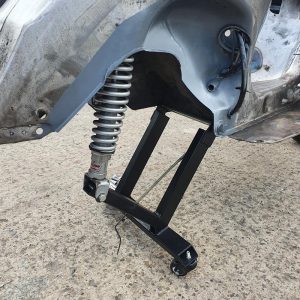 A dolly which fits to a scooter frame via the standard engine mount and the shock mount and allows you to move/store your engineless scooter with ease.  title