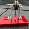 A crank in an adjustable crank truing stand with a red base with jbfab.co.uk on it
