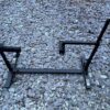 Lambretta engine test bed, powder coated in black, shown upright on some gravel.