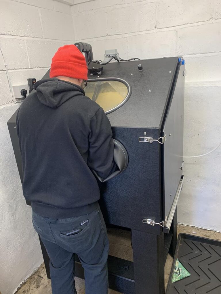 Jon Betts vapour blasting using a machine in his workshop