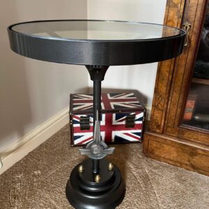 Side view of a Morris Minor coffee table made from a genuine steering wheel with base which includes an original badge.