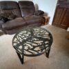 Side view of a glass fabricated table with an assortment of spanners inset within it and black powder coated legs