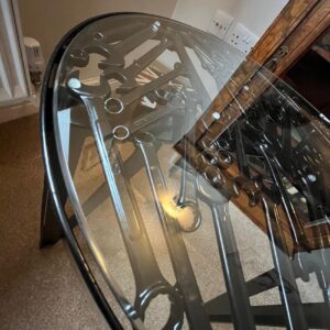 Overhead view of a glass fabricated table with an assortment of spanners inset within it