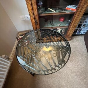 Overhead view of a glass fabricated table with an assortment of spanners inset within it