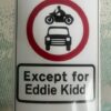 A sticker featuring a UK road sign with a motorcycle going over a car and text underneath saying 'Except for Eddie Kidd'.