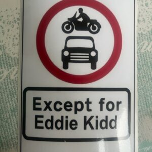 A sticker featuring a UK road sign with a motorcycle going over a car and text underneath saying 'Except for Eddie Kidd'.