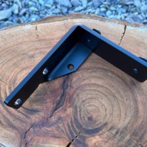 A bracket for a Morris Minor alternator/coil, shown isolated on a piece of wood.