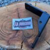 A bracket for a Morris Minor alternator/coil, shown isolated on a piece of wood.