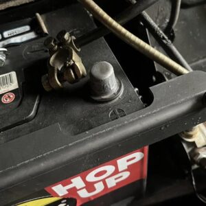 A close up of a battery strap on a Morris Minor engine