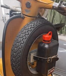 Small petrol can fixed to a spare wheel on a mustard colour Lambretta scooter