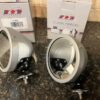 A pair of classic mini wing mirrors shown on a worktop with their boxes behind them.