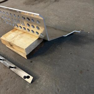A classic mini sump guard on a piece of wood, showing with fixings.