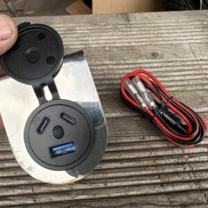 An in-car charger mount showing the ports inside with tied cable