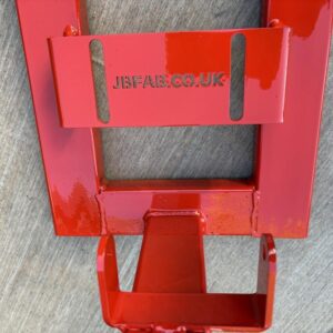 Close-up of part of a red metal engine stand for Honda C50, C70 and C90 motorbikes.