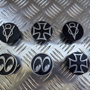 Set of 6 circular black toppers for dip and main beam switches in a car. Each has a different funky design in grey metal.